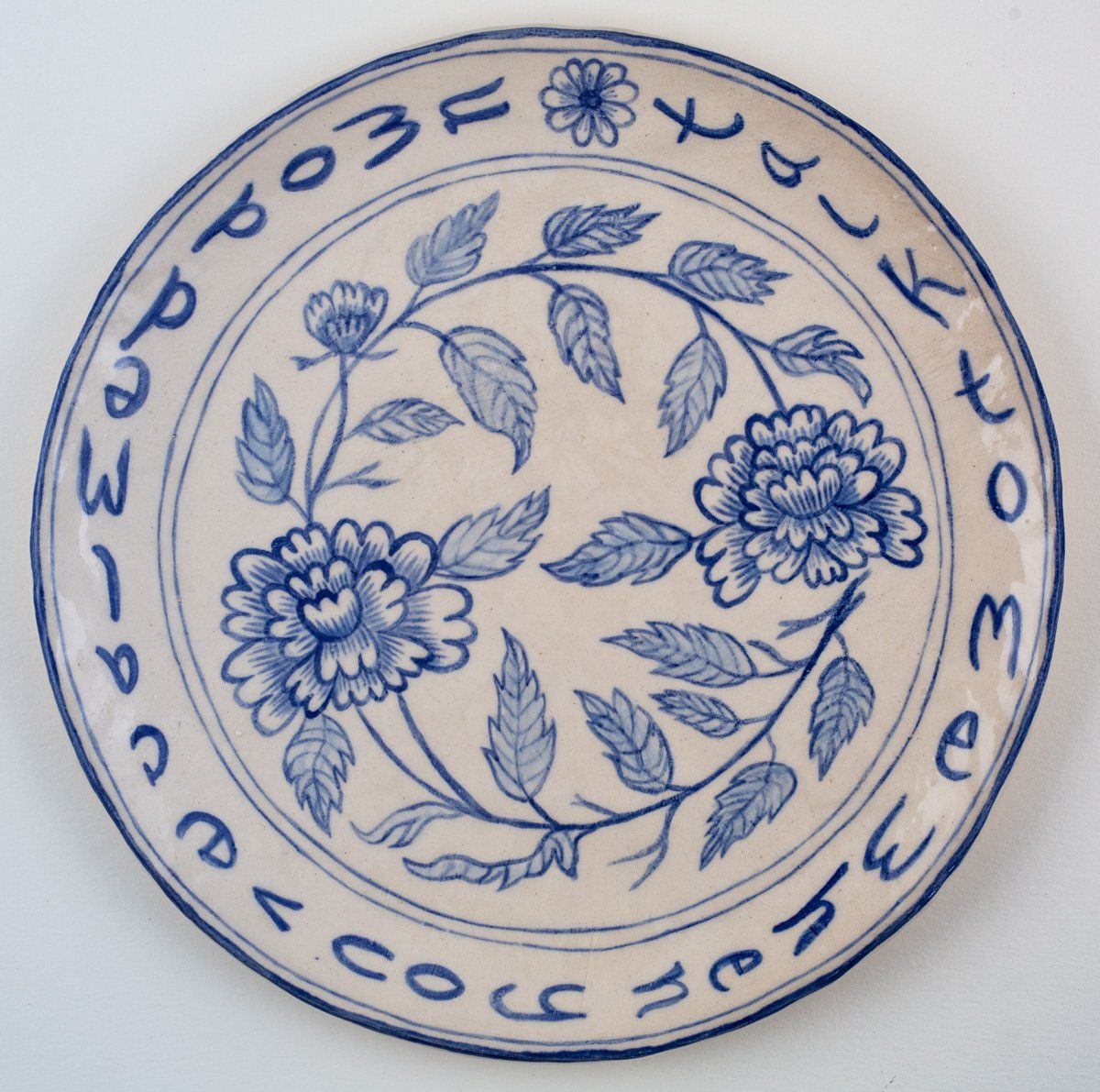 A blue and white plate with flowers and leaves on it