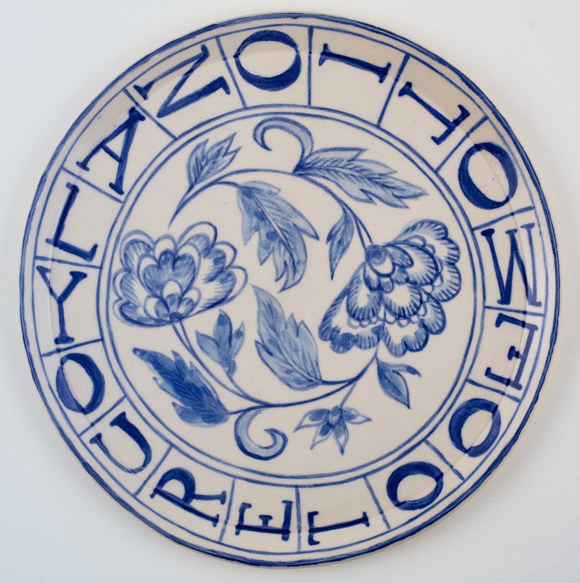 A blue and white plate with flowers and the word england in the center