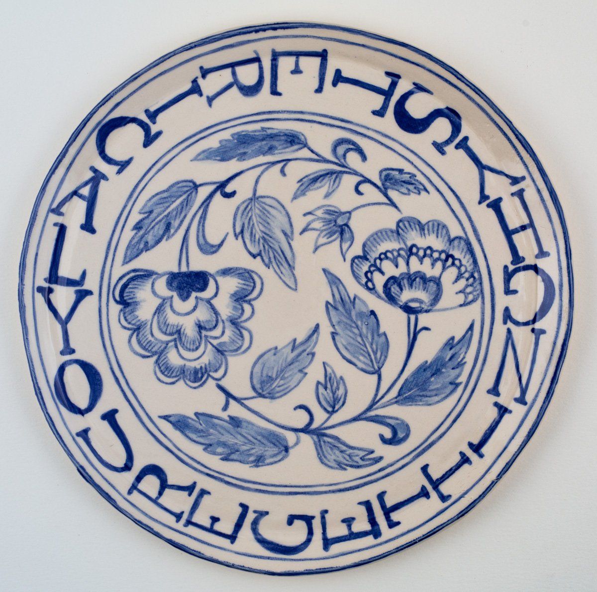 A blue and white plate with a floral design and the words 