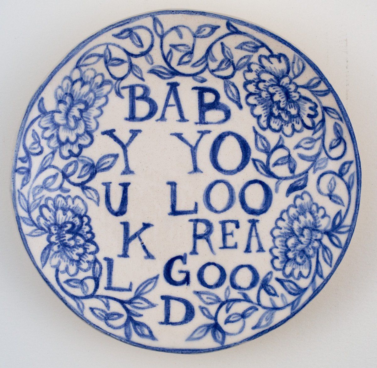 A blue and white plate that says bab y yo u loo k rea l good d