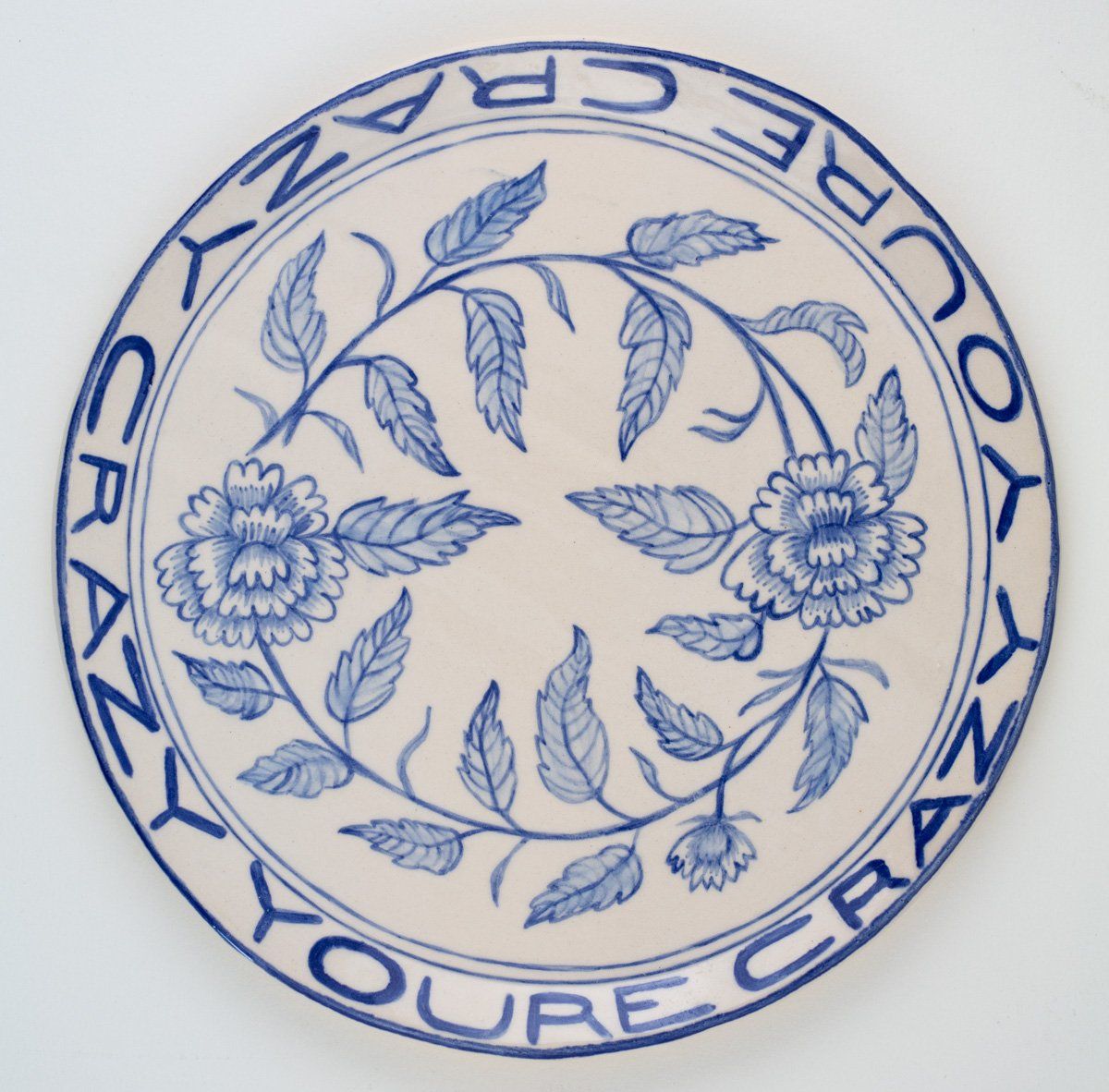 A blue and white plate with flowers and the words 