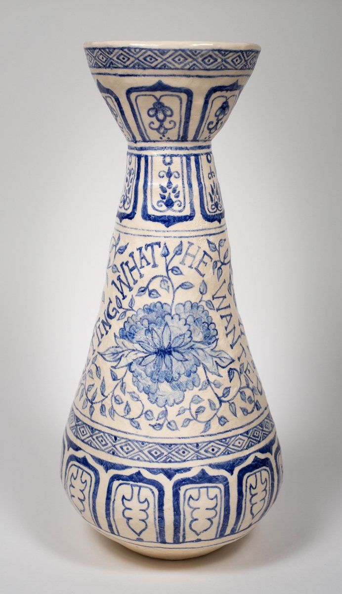A blue and white vase with the word what on it