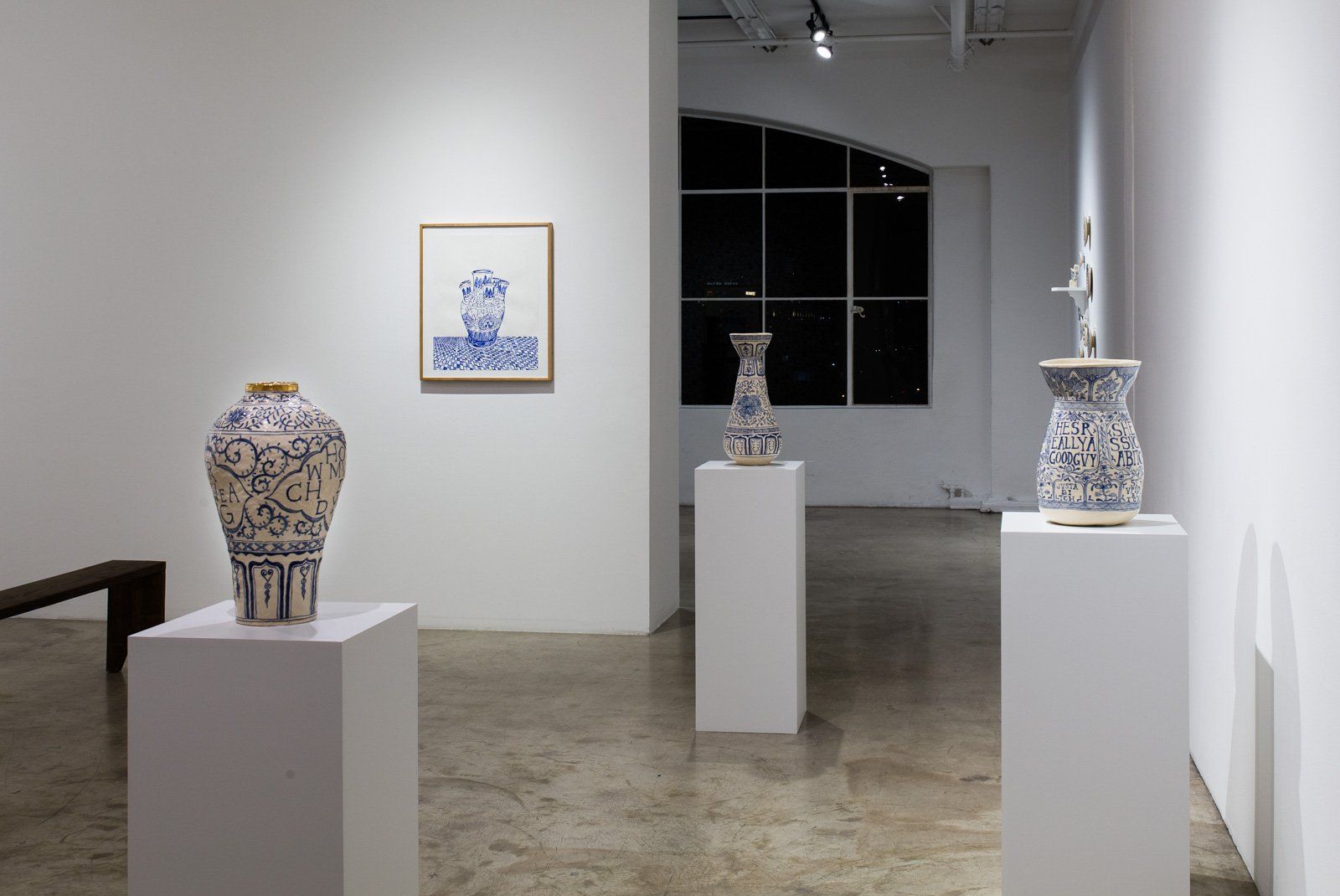 A room with a lot of vases on display in it.