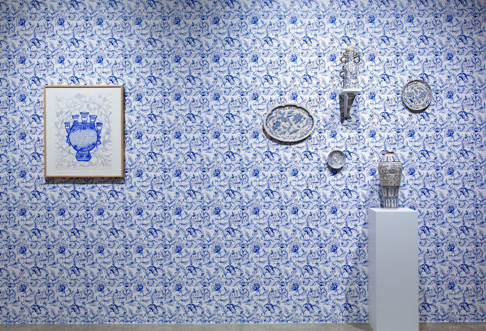 A room with a blue and white wall and a statue on a pedestal.