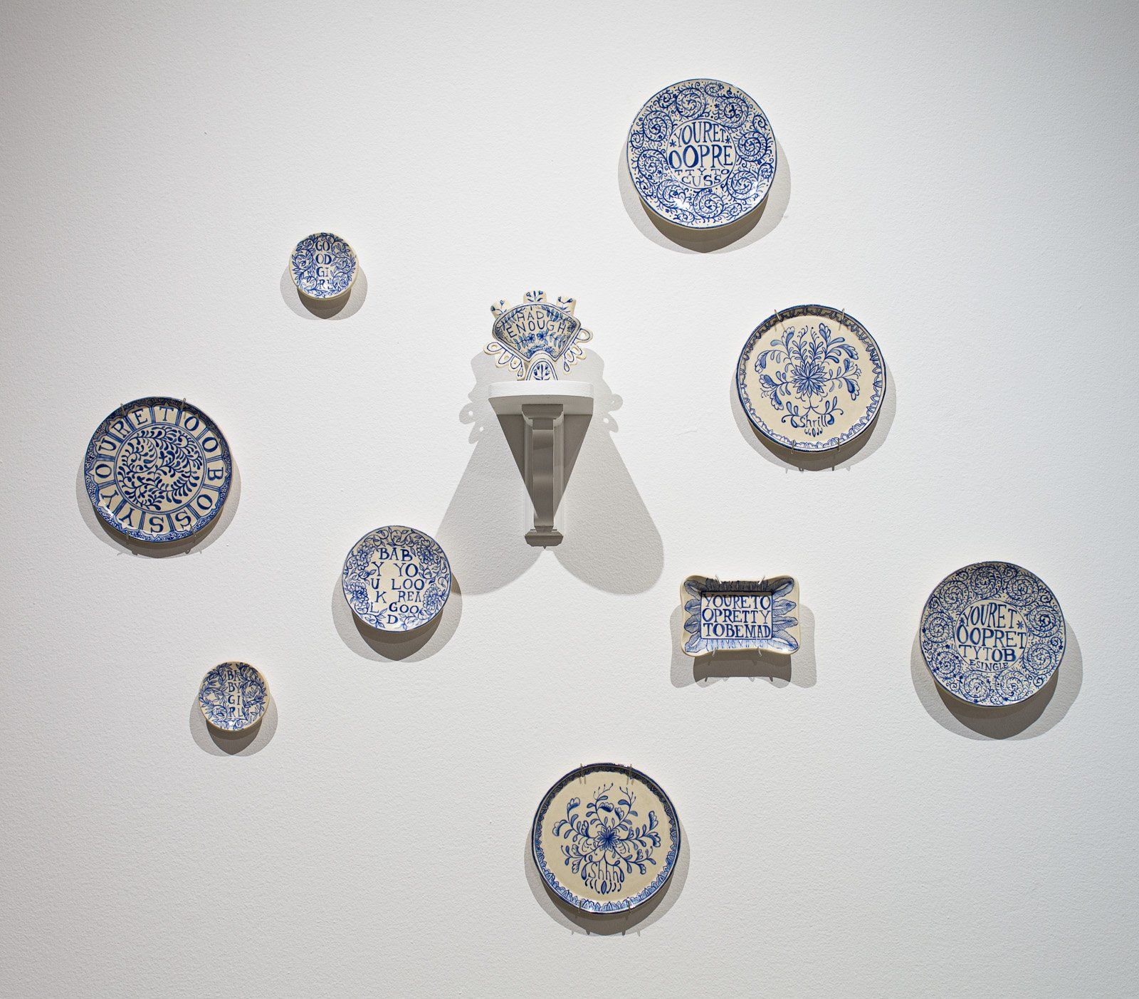 A group of blue and white plates on a white wall