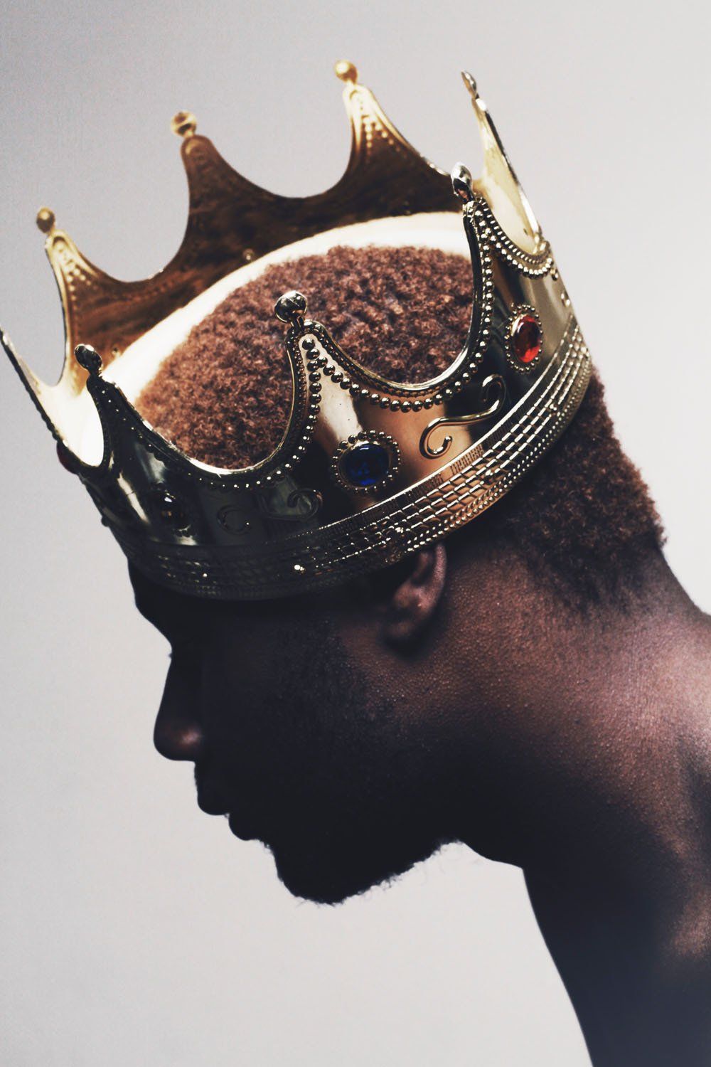 A man wearing a crown with the letter c on it