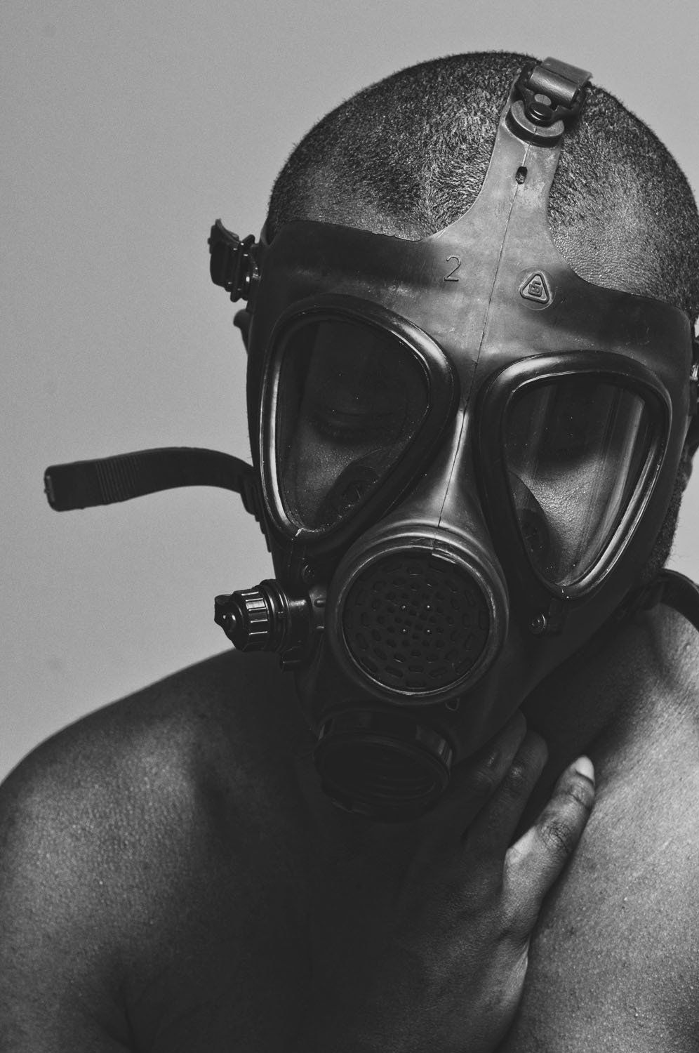 A black and white photo of a man wearing a gas mask