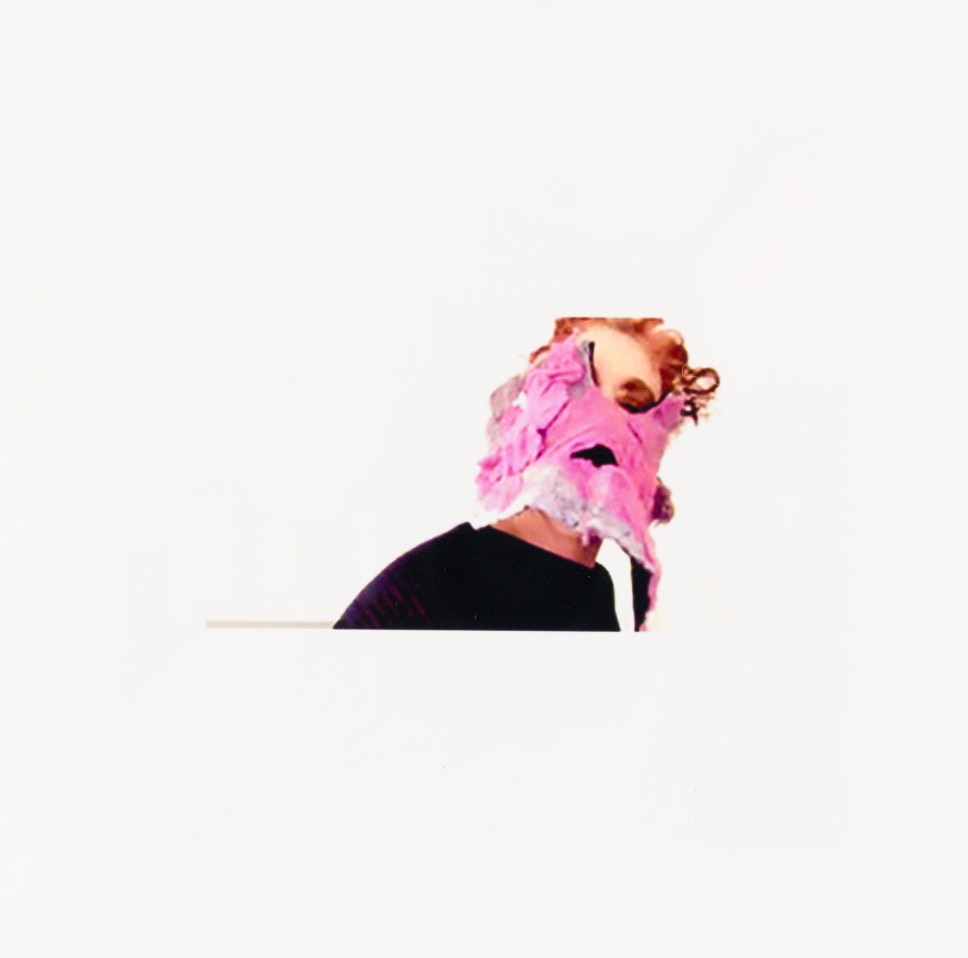 A person wearing a pink fox mask on their head.