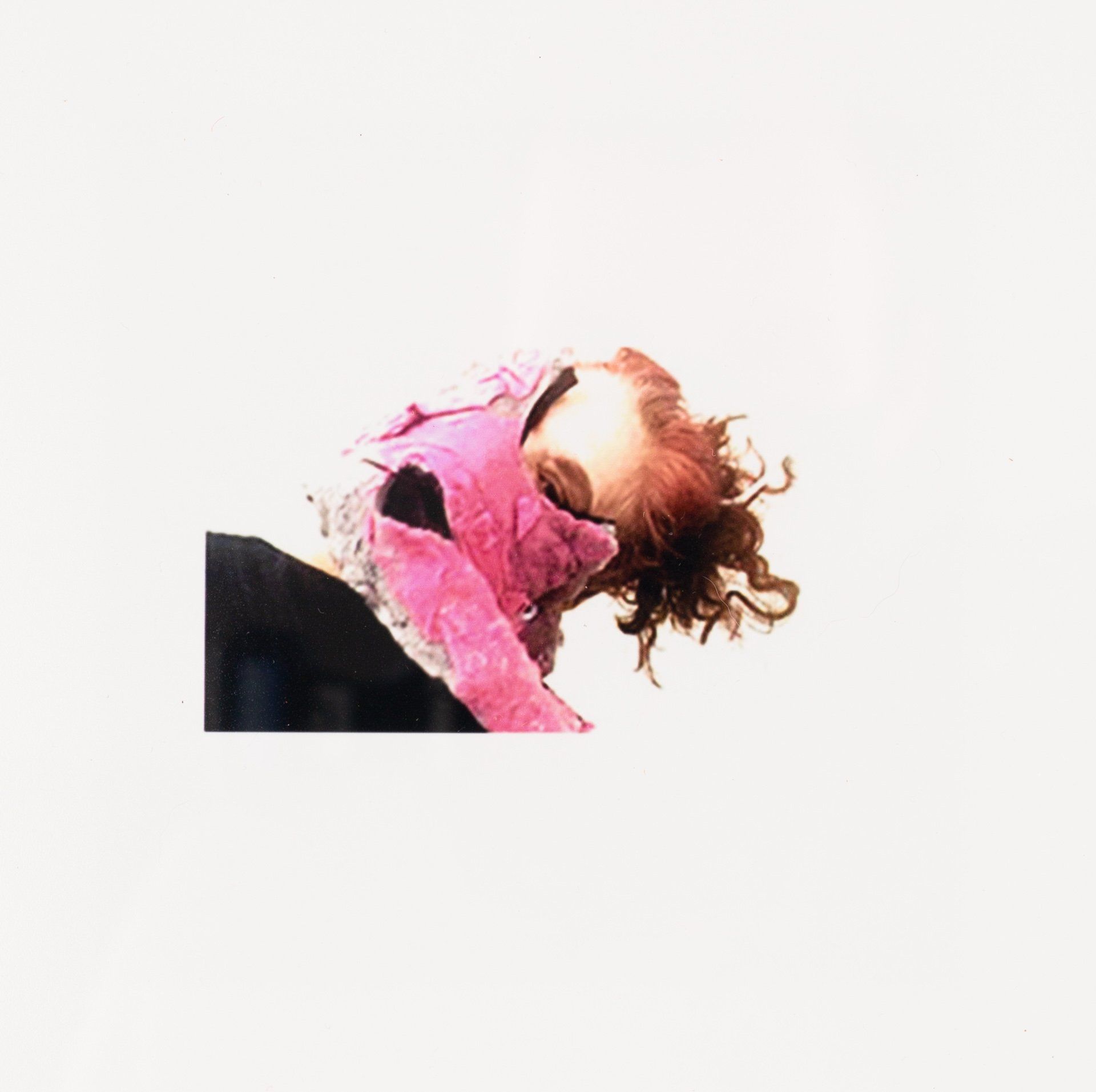 A woman is wearing a pink scarf around her neck.