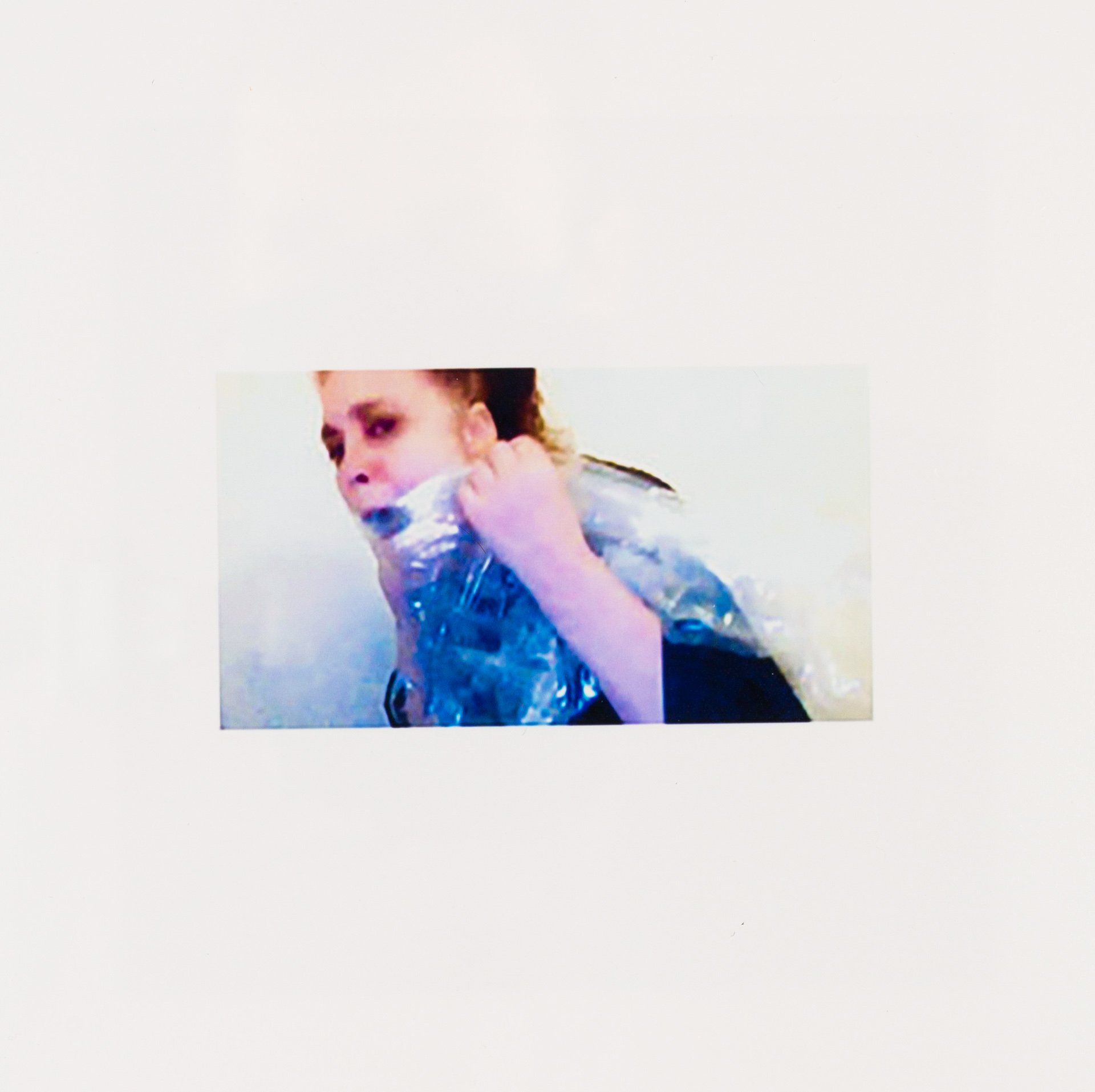 A woman is holding a plastic bag over her mouth.