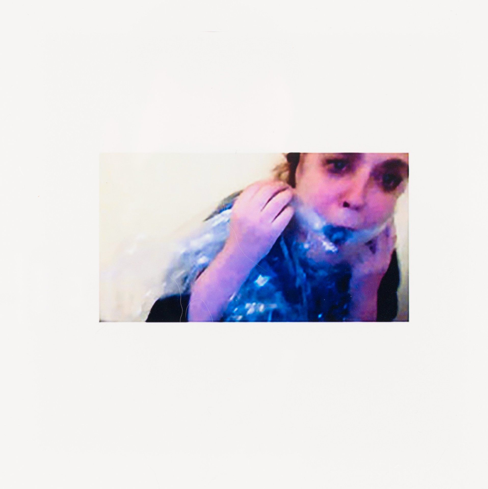 A woman is holding a plastic bag over her mouth.