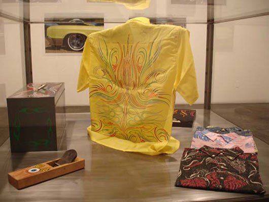 A yellow shirt is sitting on a glass table next to a wooden plane.