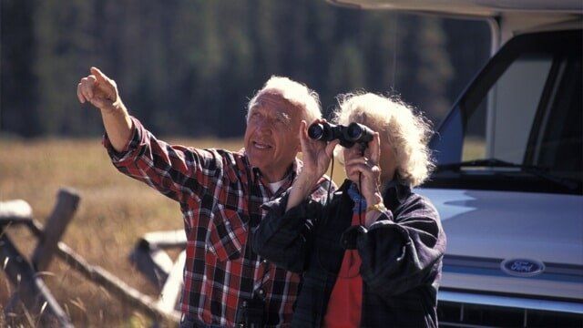 Senior Couple Looking Through Binoculars — RV Parking in Peroria, IL Senior Couple Looking Through Binoculars — RV Parking in Peroria, IL