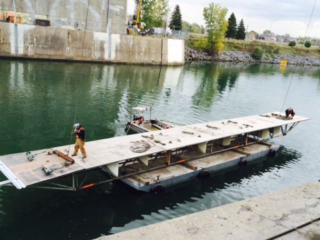 Un homme debout sur un quai à côté d'un plan d'eau