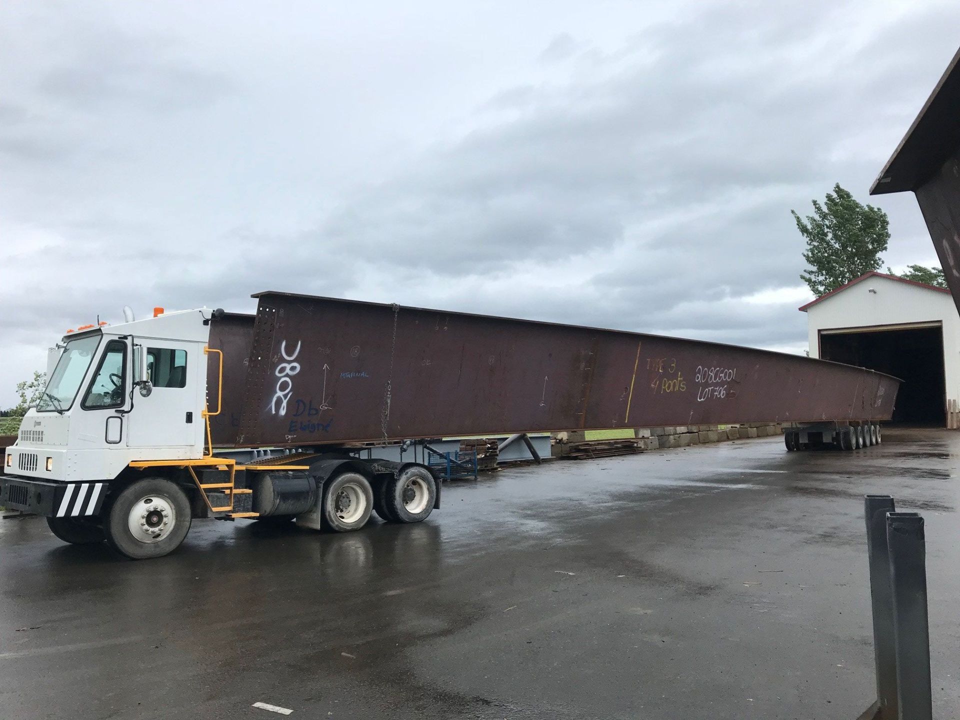 Un camion transporte un gros morceau de métal sur une remorque.