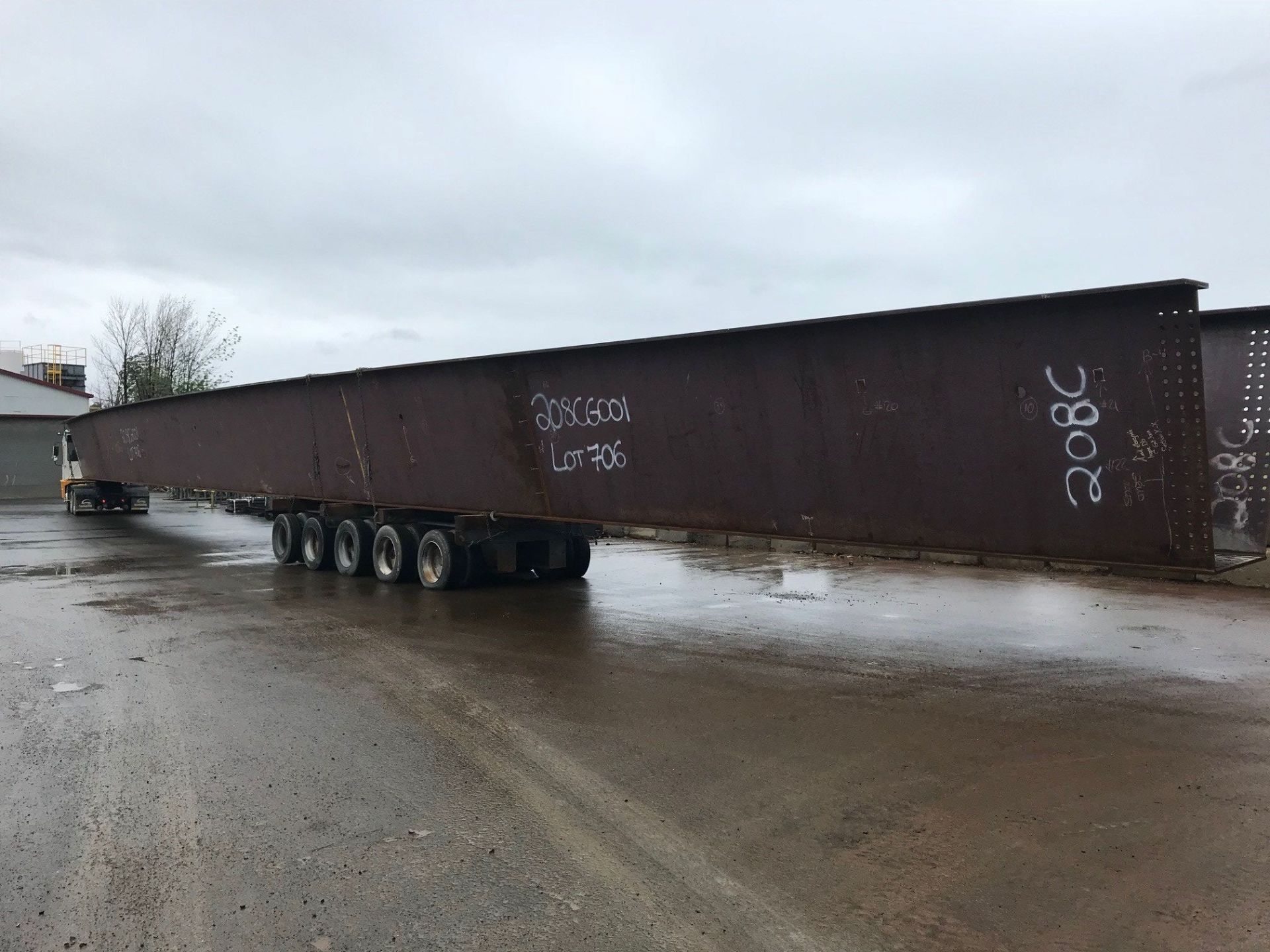 Un camion transporte un très long morceau de métal sur une remorque.