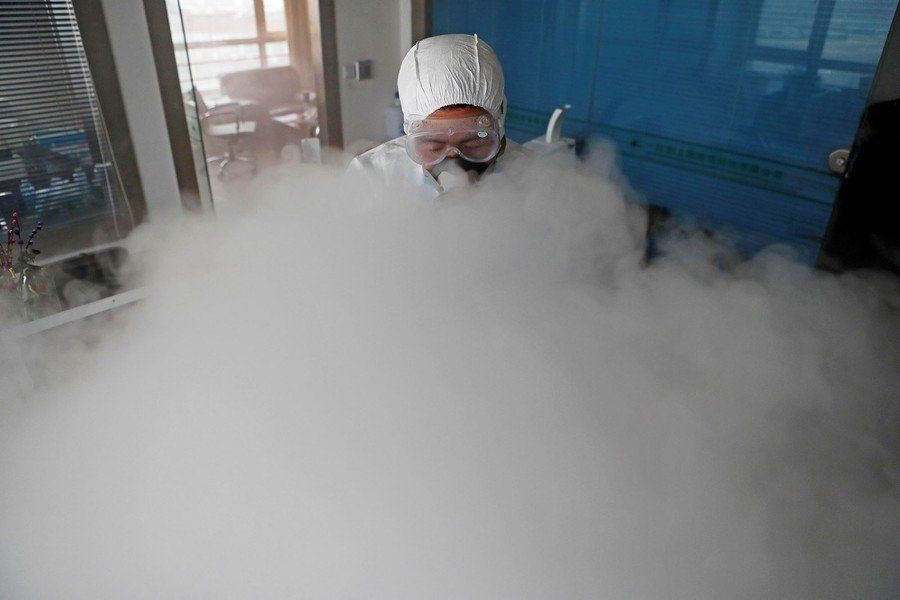 Person in protective suit amid a large cloud of vapor.