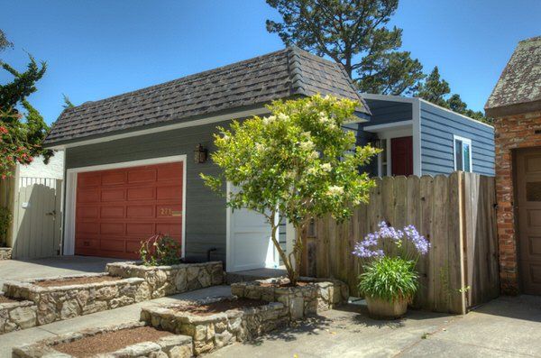 Evening blue siding with a reddish garage door and arctic white trim.