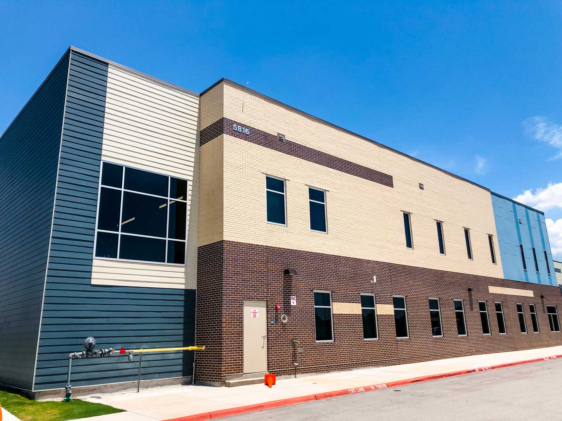 Modern commercial building with beige and gray exterior on a sunny day