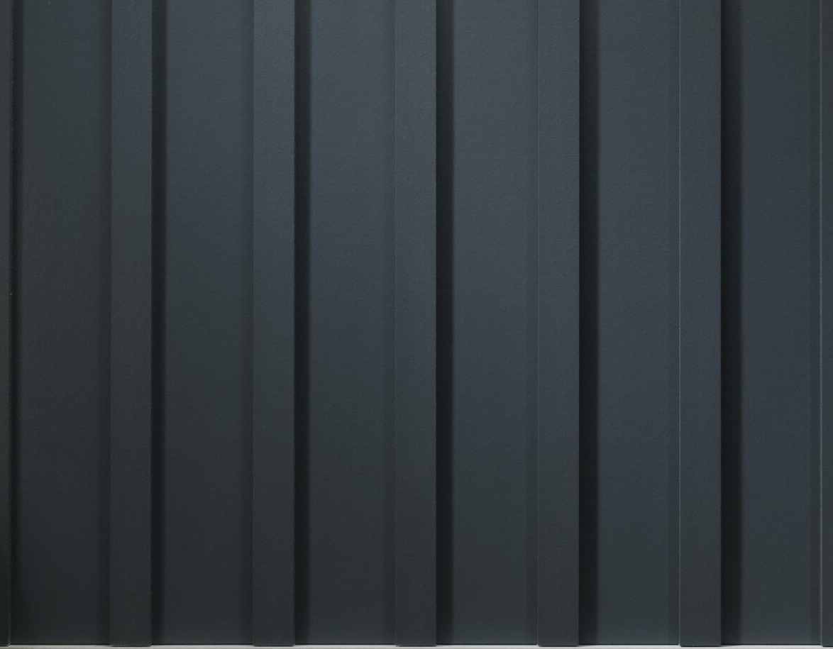 Dark gray vertical panels with narrow black seams, like a metal wall or siding.