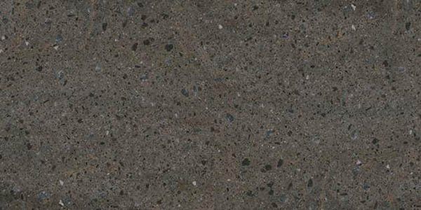 A close-up of dark gray, speckled stone or quartz countertop material with fine light and dark flecks.