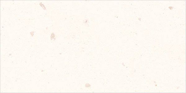Off-white, textured surface with small, scattered beige and brown flecks resembling handmade paper or stone.