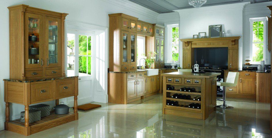A light-wood kitchen with a central wine rack island, matching cabinetry, and glossy flooring in a bright, spacious room.