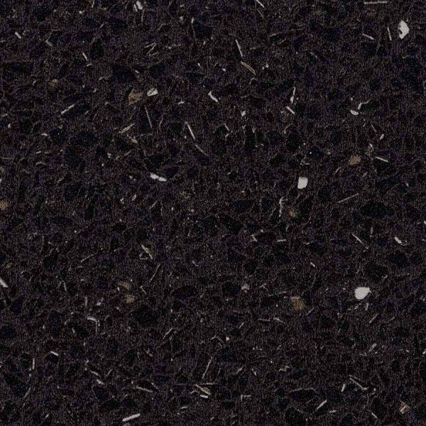 A close-up of a dark black, polished countertop surface featuring embedded flecks of white and gray stone fragments.