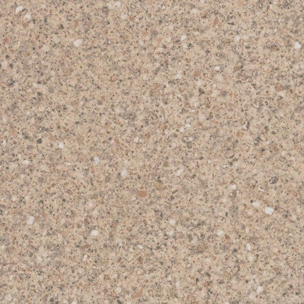 A close-up of a speckled granite or laminate surface with a warm, sandy beige and brown granular texture.