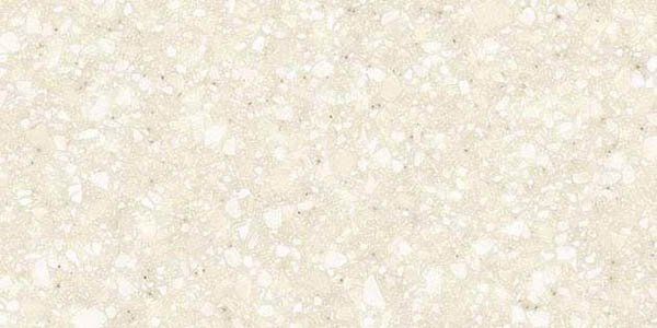 Close-up of a light beige, speckled countertop surface with fine white and cream-colored flecks.
