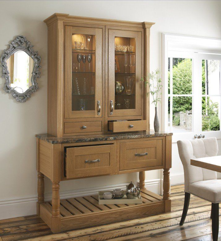 A wooden hutch with a glass-front display, two drawers, a stone-style countertop, and a slatted lower shelf.