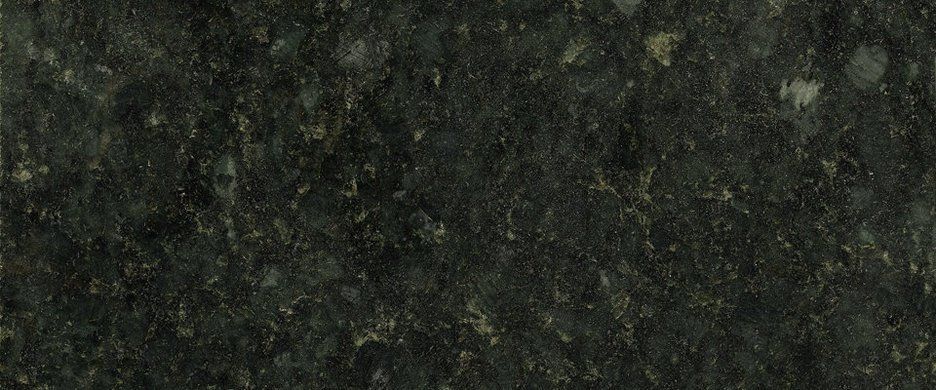 A close-up of dark green, polished granite stone featuring a mottled, speckled texture with grey and black inclusions.