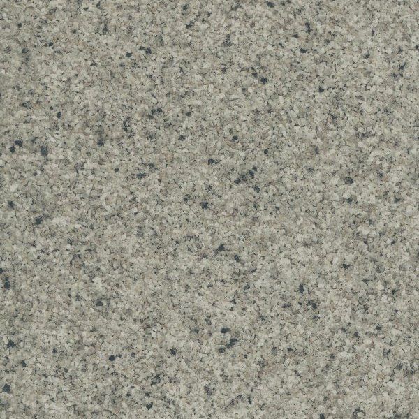 Close-up of a speckled granite surface with light grey, tan, and dark grey flecks in a uniform texture.