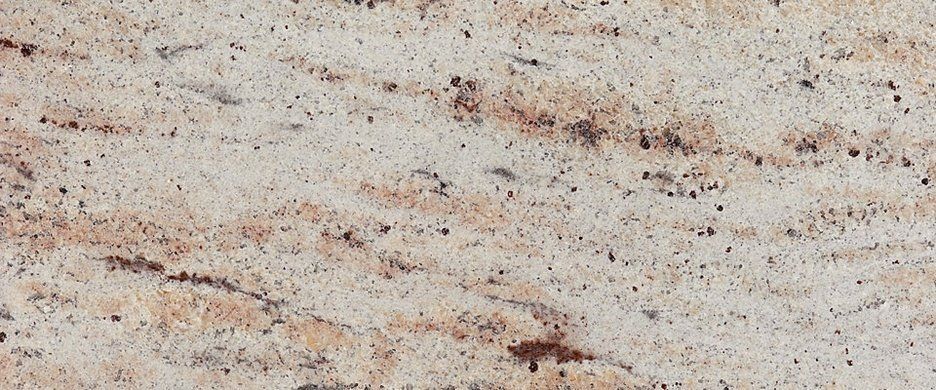 Cream-colored natural stone slab featuring tan, brown, and dark gray speckled, flowing veining patterns.