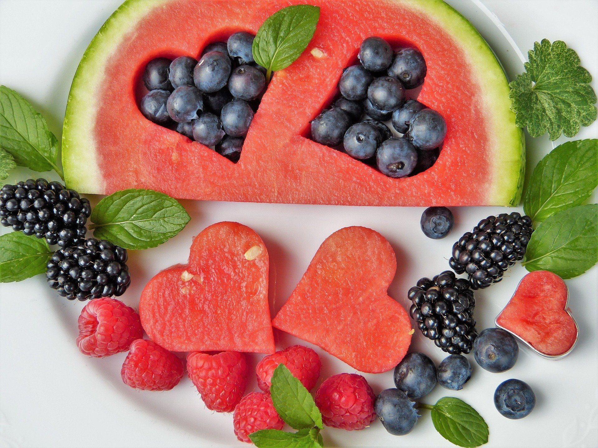 Ein weißer Teller mit Wassermelone, Heidelbeeren, Himbeeren und Brombeeren
