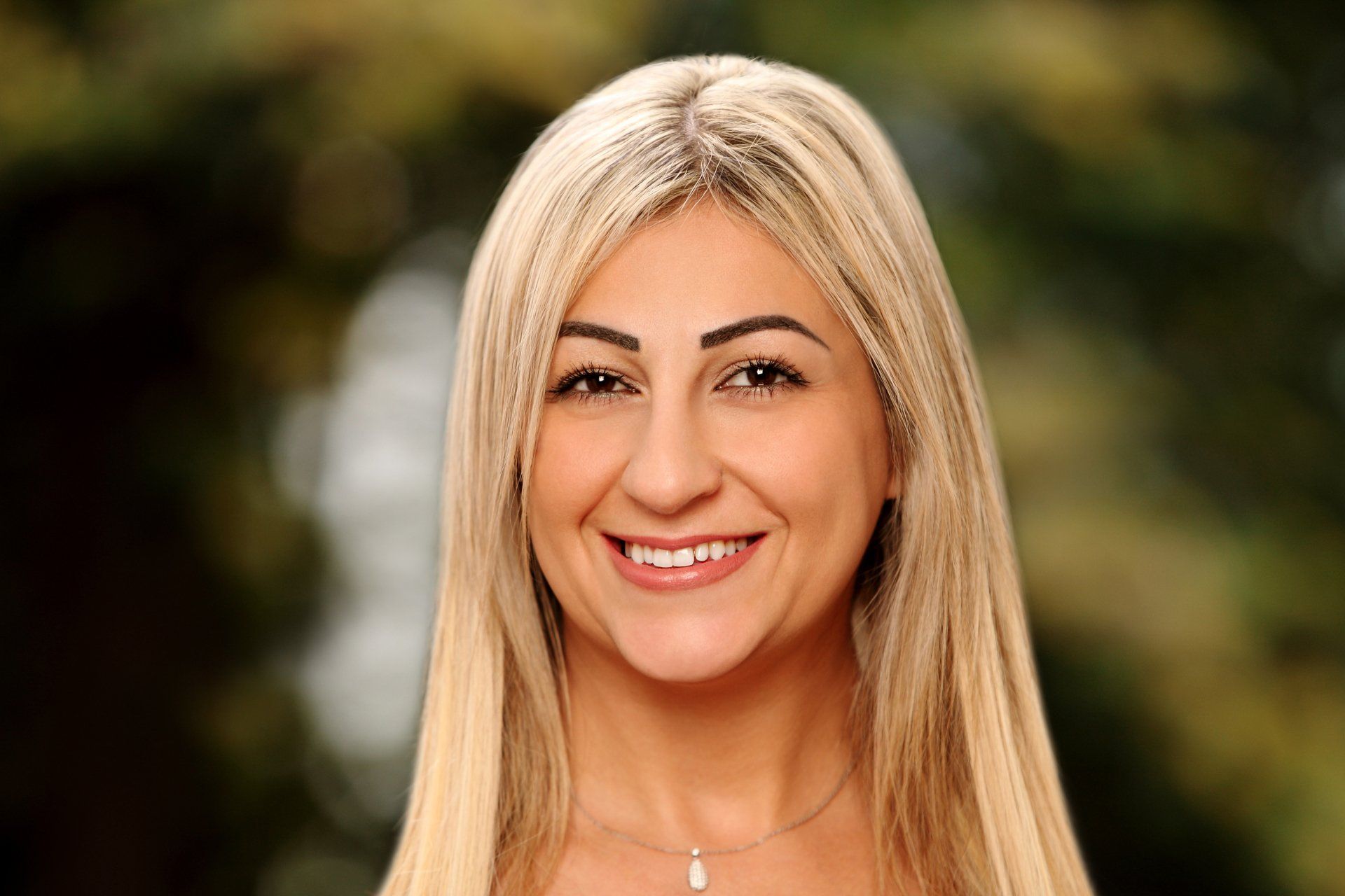 Eine Frau mit langen blonden Haaren lächelt in die Kamera.