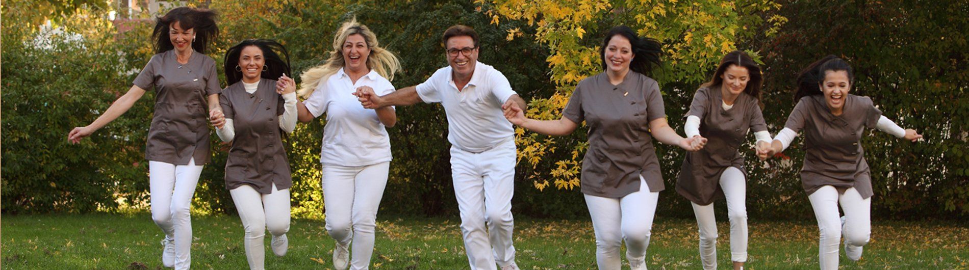 Eine Gruppe Frauen läuft händchenhaltend über ein Feld.