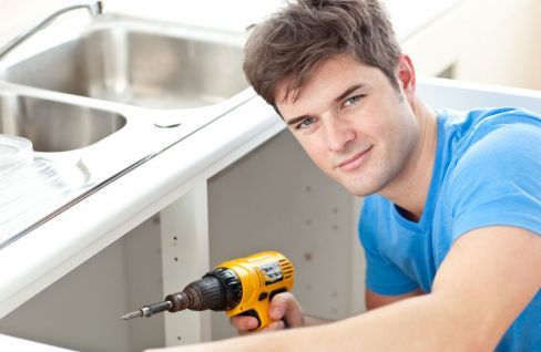 Worker from a building company works on kitcken renovation in Austral