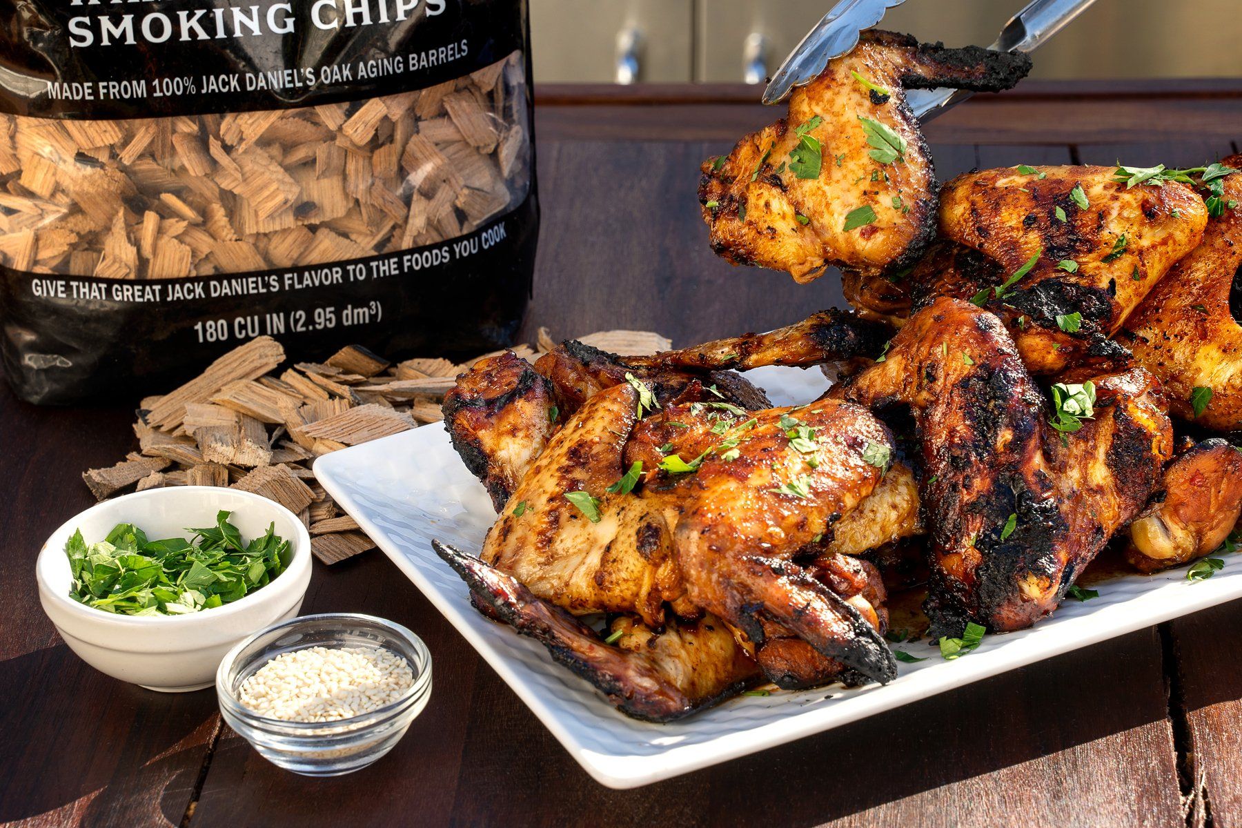 Photo of Fiery Hot Wings with blue cheese dip and a bag of Jack Daniel's smoking chips in the background