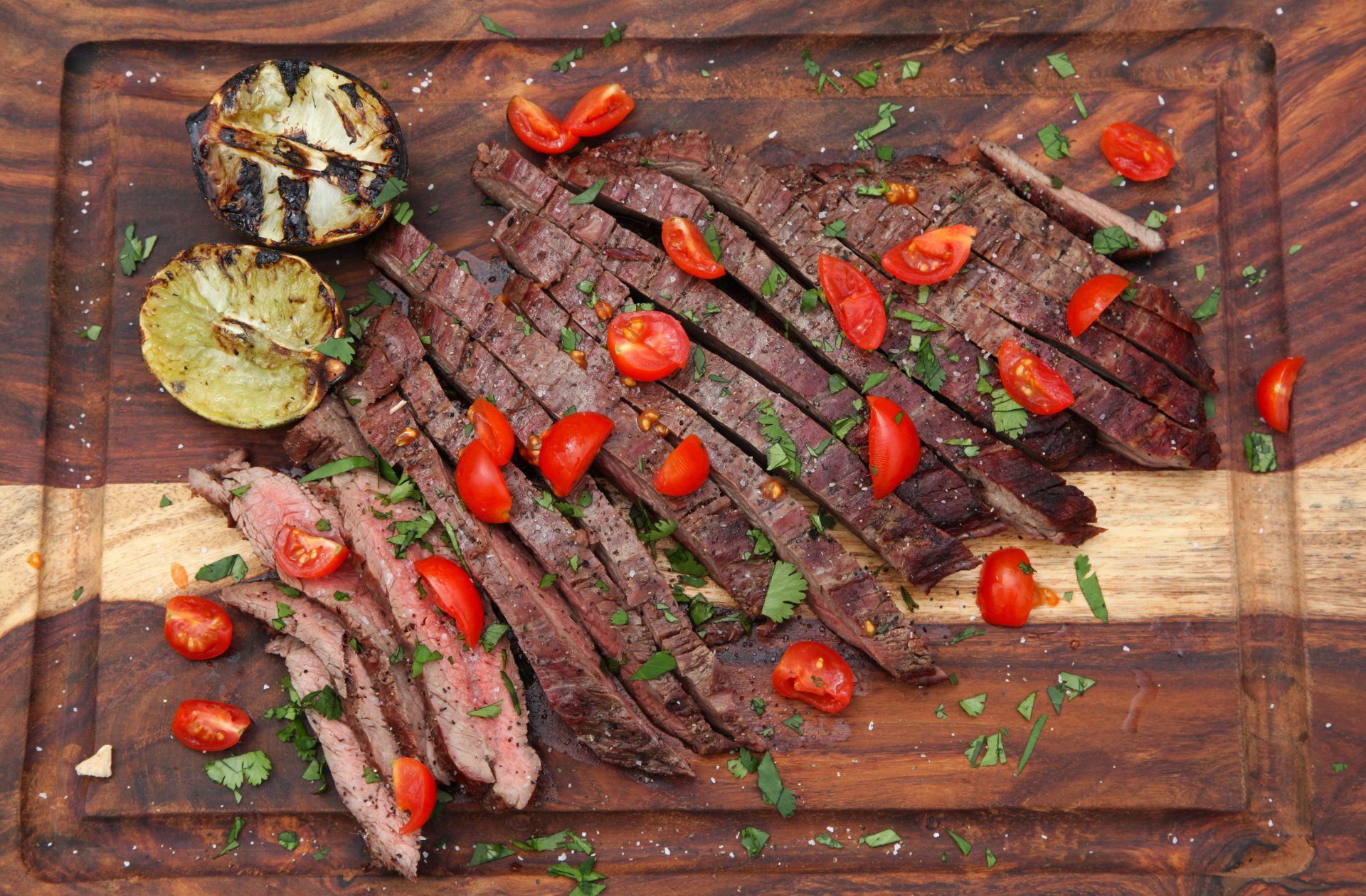 Birdseye photo of a cutting board with sliced grilled flank steak