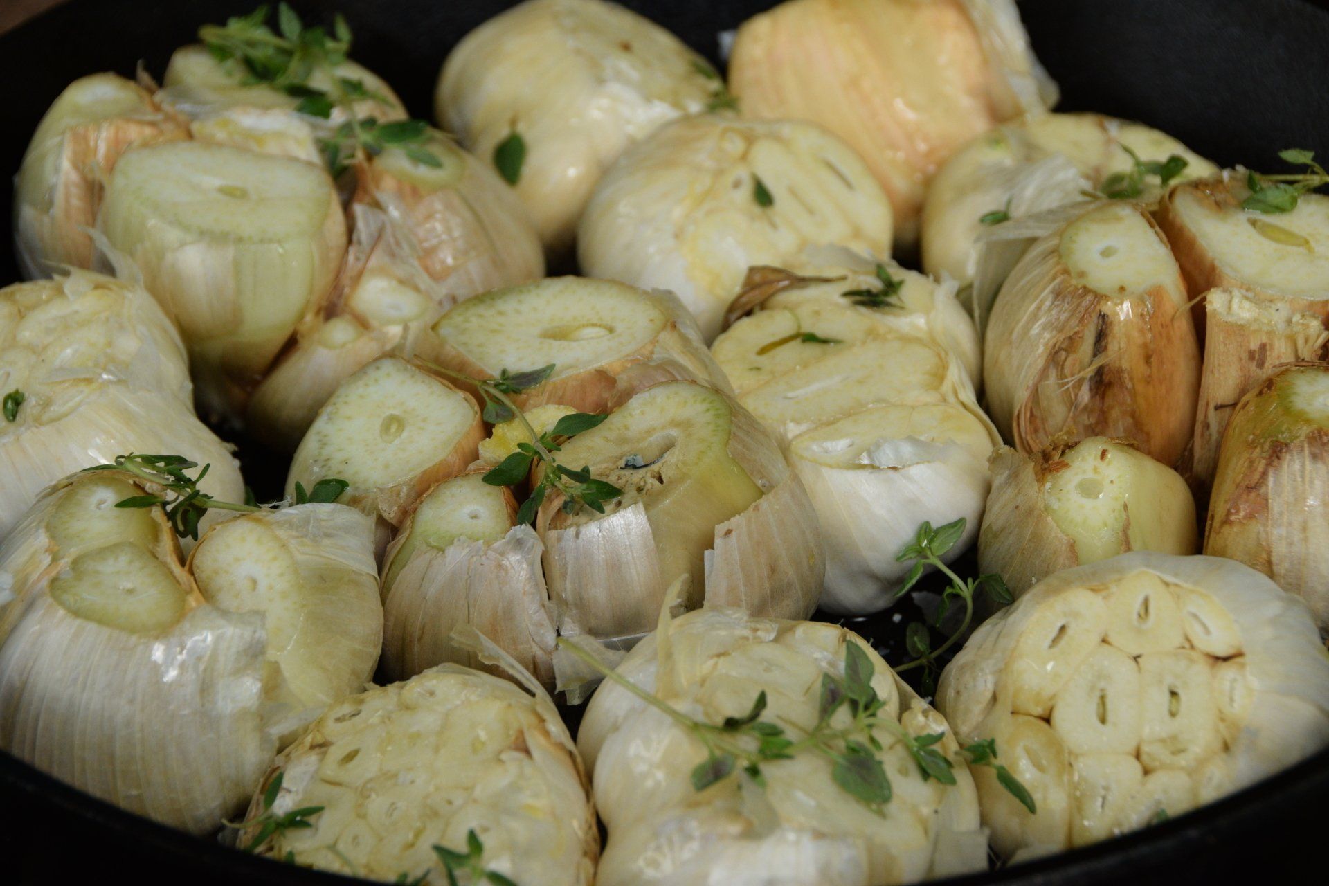 closeup of cloves of garlic sitting in a cast iron pan