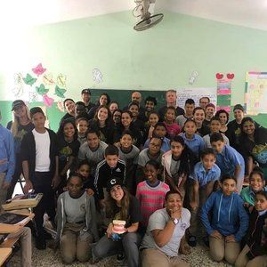 A large group of people are posing for a picture in a classroom.