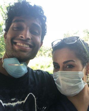 A man and a woman wearing face masks are posing for a picture.