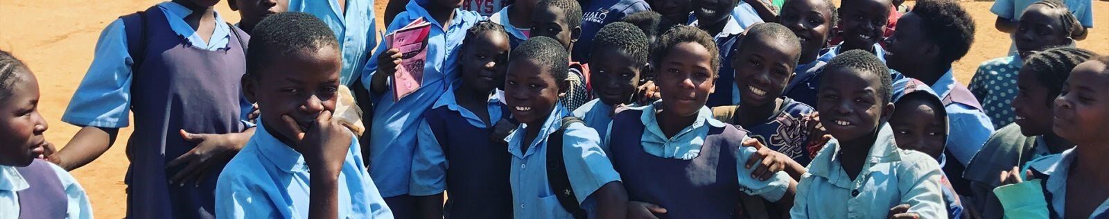 A group of children in blue uniforms are posing for a picture.