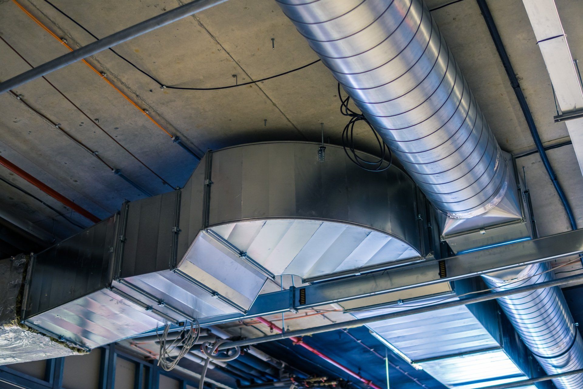 A large metal pipe is hanging from the ceiling of a building.