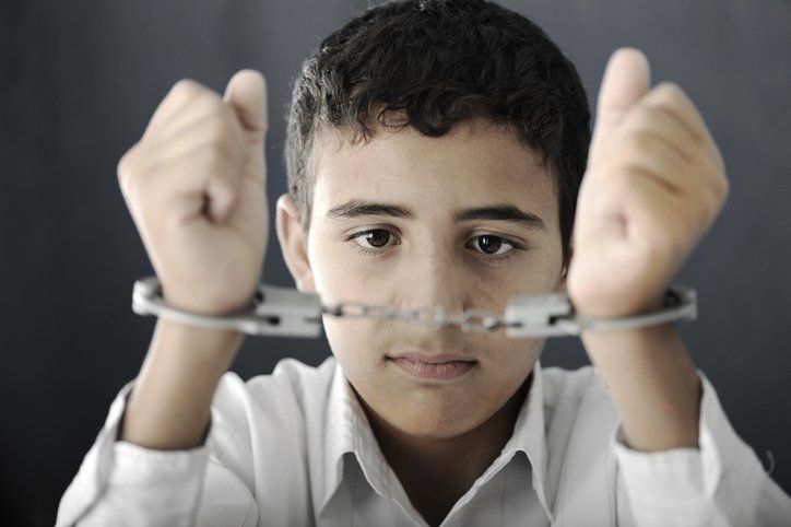 Kid with handcuffs on hands — Glen Burnie, MD — The Law Offices Of Fischer & Putzi, P.A. Kid with handcuffs on hands — Glen Burnie, MD — The Law Offices Of Fischer & Putzi, P.A.
