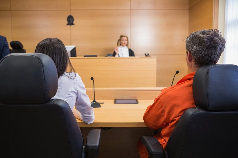 Lawyer and Client Listening to Judge — Glen Burnie, MD — The Law Offices Of Fischer & Putzi, P.A. Lawyer and Client Listening to Judge — Glen Burnie, MD — The Law Offices Of Fischer & Putzi, P.A.