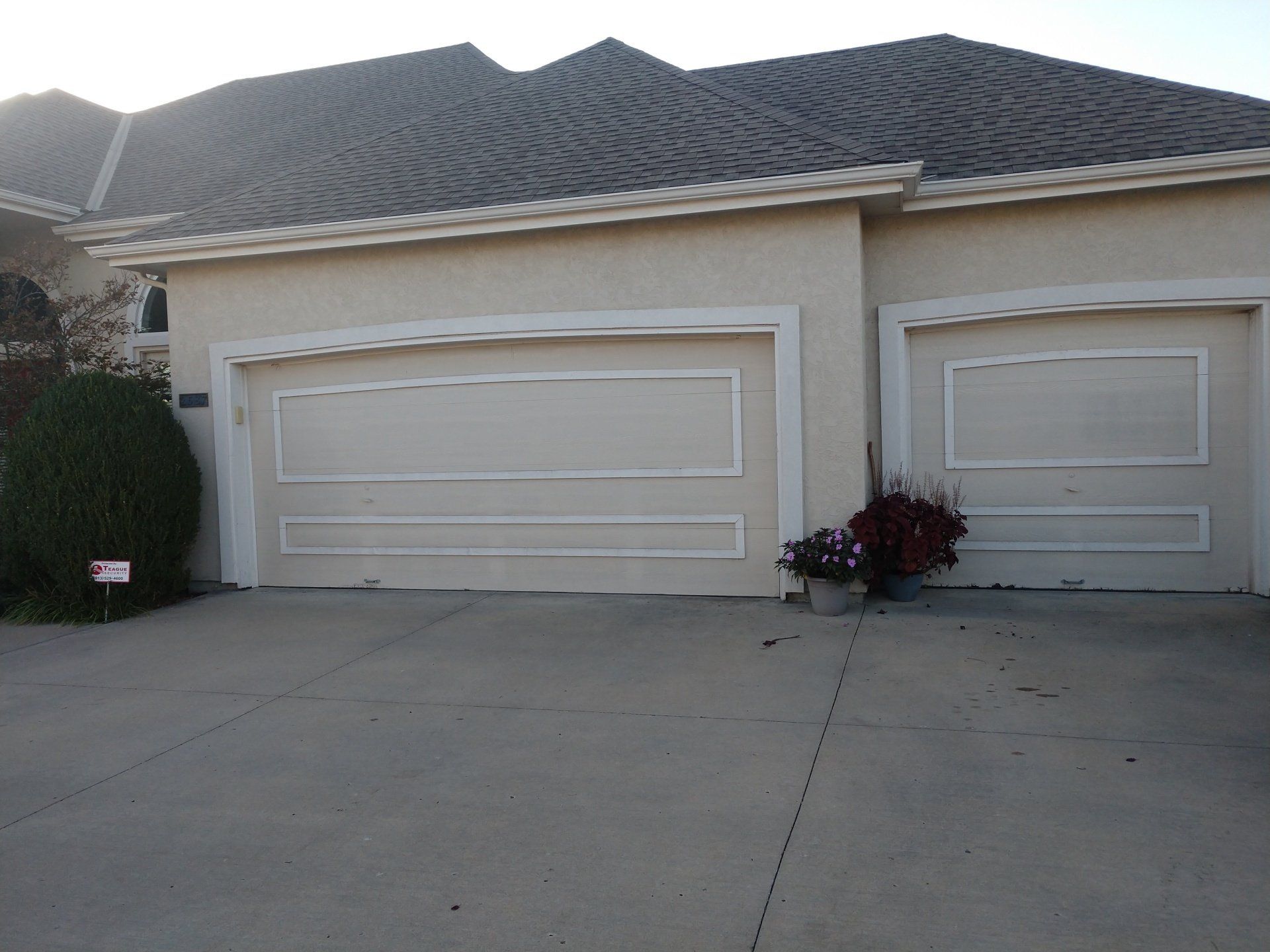 Suburban house with two white garage doors and a concrete driveway