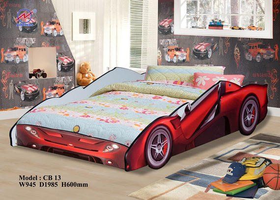 Red race car bed in a child's room with car-themed wallpaper.