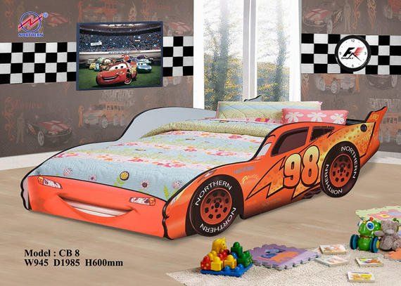 A child's bedroom with a race car bed featuring Lightning McQueen. Checkered flag decor, toys on the floor.
